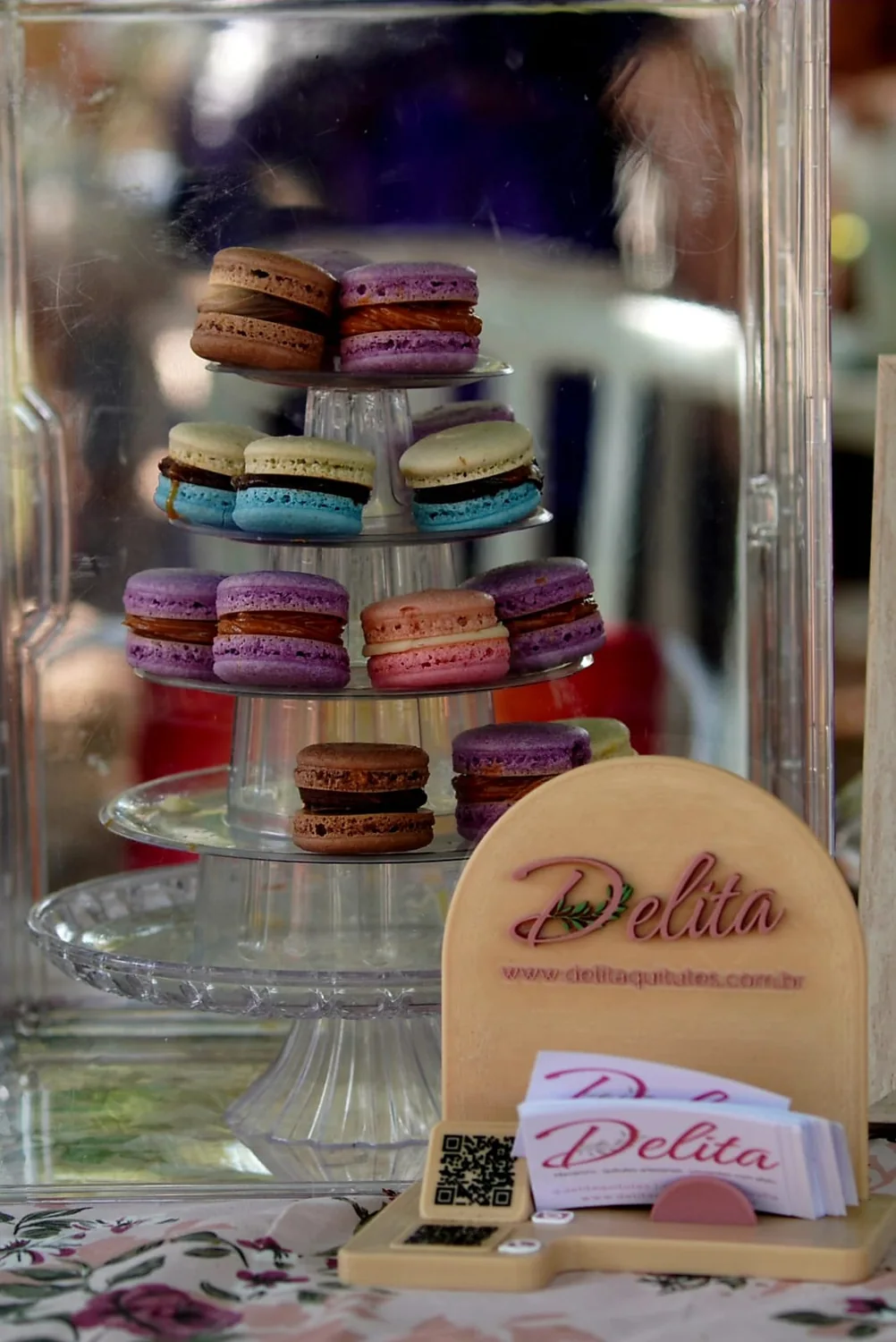 Expositor Delita em evento com torre de macarons, cartões e QR code
